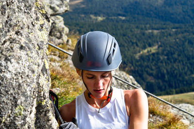 Portrait of woman climbing rock on mountain