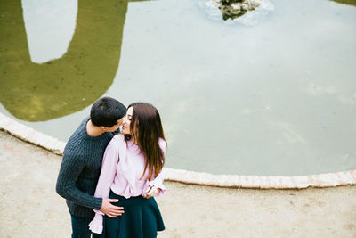 Rear view of couple kissing at beach