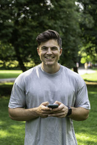 Portrait of smiling young man using smart phone