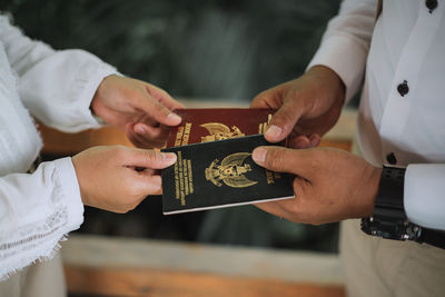 Midsection of people holding passport