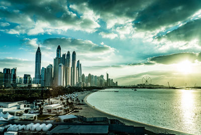 Buildings in city against cloudy sky