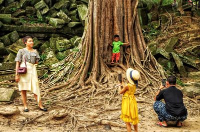 Rear view of people standing in forest