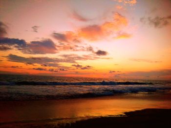 Scenic view of sea against dramatic sky during sunset