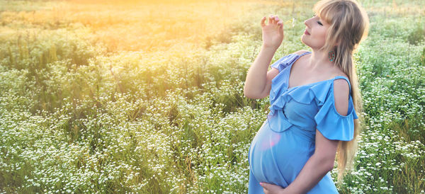 Portrait of young woman standing against plants