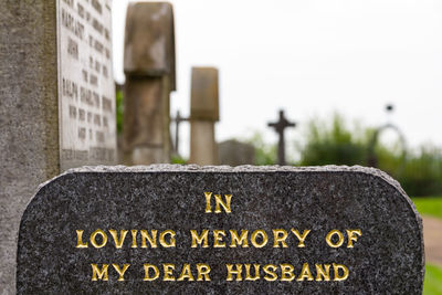 Close-up of text on gravestone at cemetery. in loving memory of my dear husband