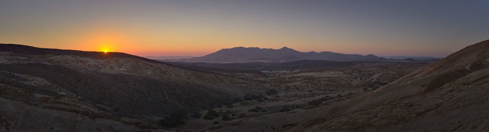 Scenic view of mountains against clear sky during sunset