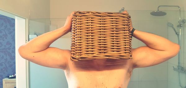 Midsection of person holding drink in bathroom