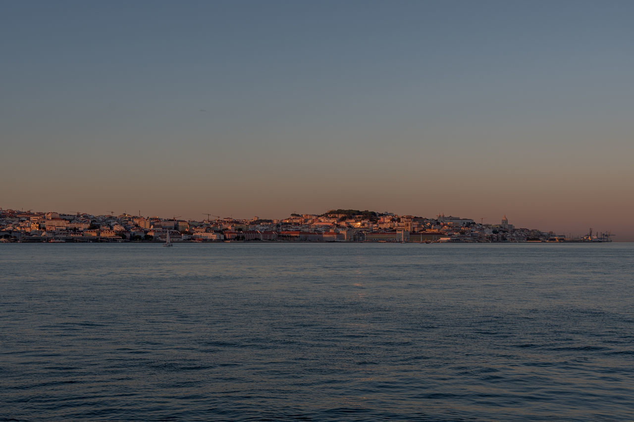 SCENIC VIEW OF SEA AGAINST CLEAR SKY DURING SUNSET