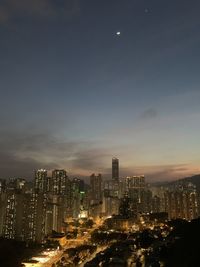 Illuminated buildings in city against sky at night