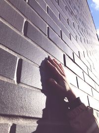 Low angle view of person holding umbrella against built structure