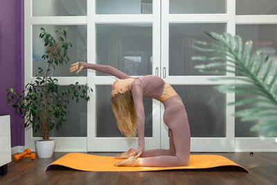 Beautiful young woman practicing sports at home. sporty girl exercising yoga. sport and 
