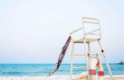 Lifeguard chair at beach against clear sky