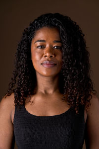 Portrait of young woman against black background