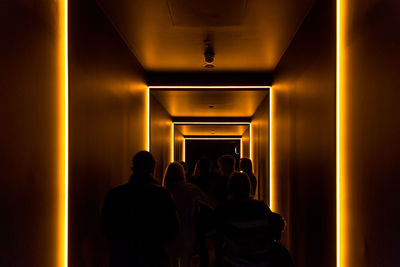 People in illuminated corridor