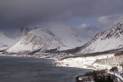 Scenic view of snowcapped mountains by sea against sky