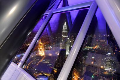 Modern buildings seen through glass window at night