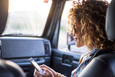 Close-up of woman using smart phone in car