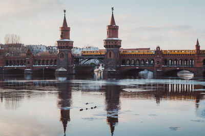 Reflection of oberbaum bridge in river against sky