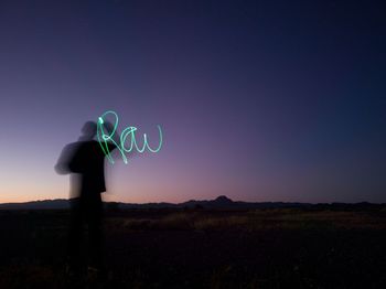 Silhouette man standing on field against sky