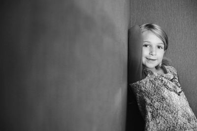Portrait of cute girl standing in corner