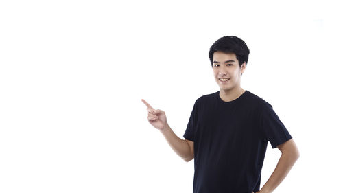 Portrait of young man standing against white background