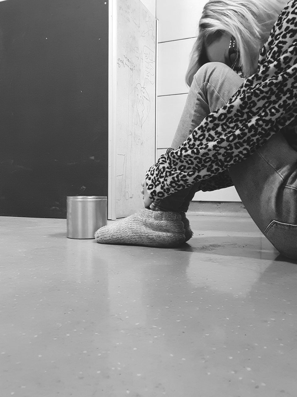 SIDE VIEW OF YOUNG WOMAN SITTING ON FLOOR IN ROOM