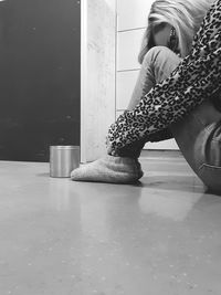 Side view of woman sitting on floor