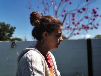 Side view of thoughtful teenage girl looking away against sky