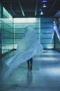 Low section of young woman holding plastic on floor