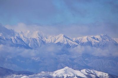 Scenic view of snow covered mountain against cloudy sky