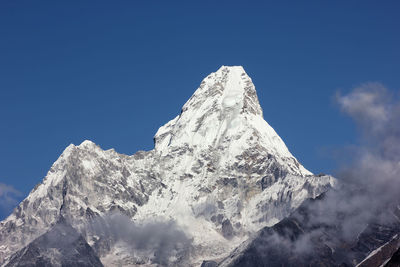 Low angle view of snow against clear blue sky