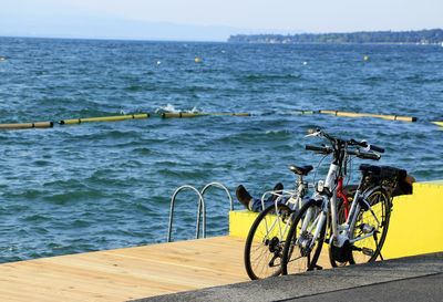 Two bicycles parked on the shore of geneva lake