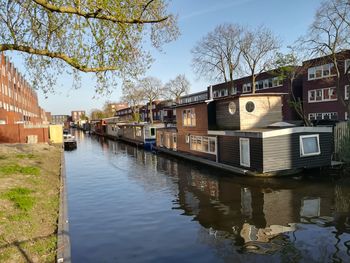 Canal amidst buildings against sky