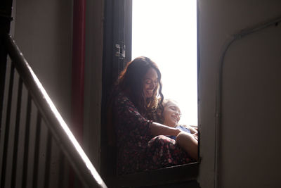 Mother sitting with daughter at doorway