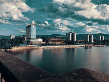 Sea by buildings against sky in city