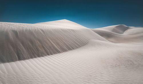 Sand dunes in desert against sky