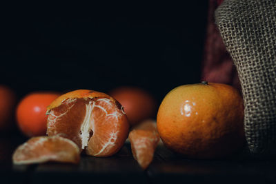 Close-up of oranges on table against black background