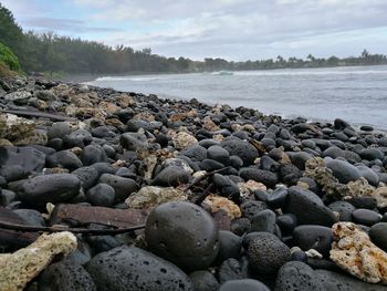 Surface level of pebble beach against sky