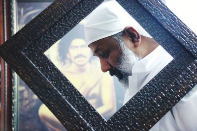 Side view of man seen through picture frame