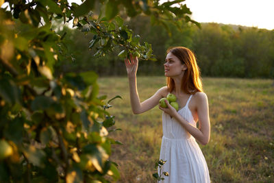 Woman standing by tree