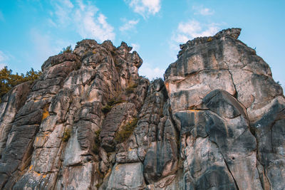 Low angle view of rocky mountains against sky