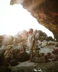 Full length of young man standing on rock