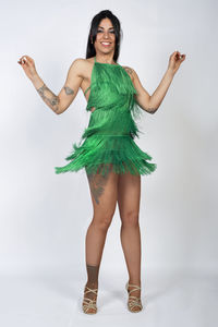 Portrait of young woman standing against white background