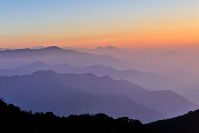 Scenic view of silhouette mountains against sky at sunset