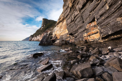 Rock formation on beach against sky