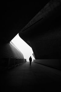 Rear view of man walking in tunnel