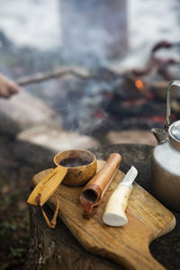 Hot tea in ladle by knife on cutting board