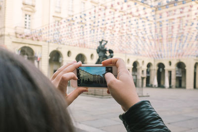 Midsection of woman photographing with mobile phone