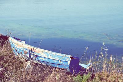 Abandoned boat moored at shore