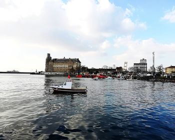 Boat in river against buildings in city